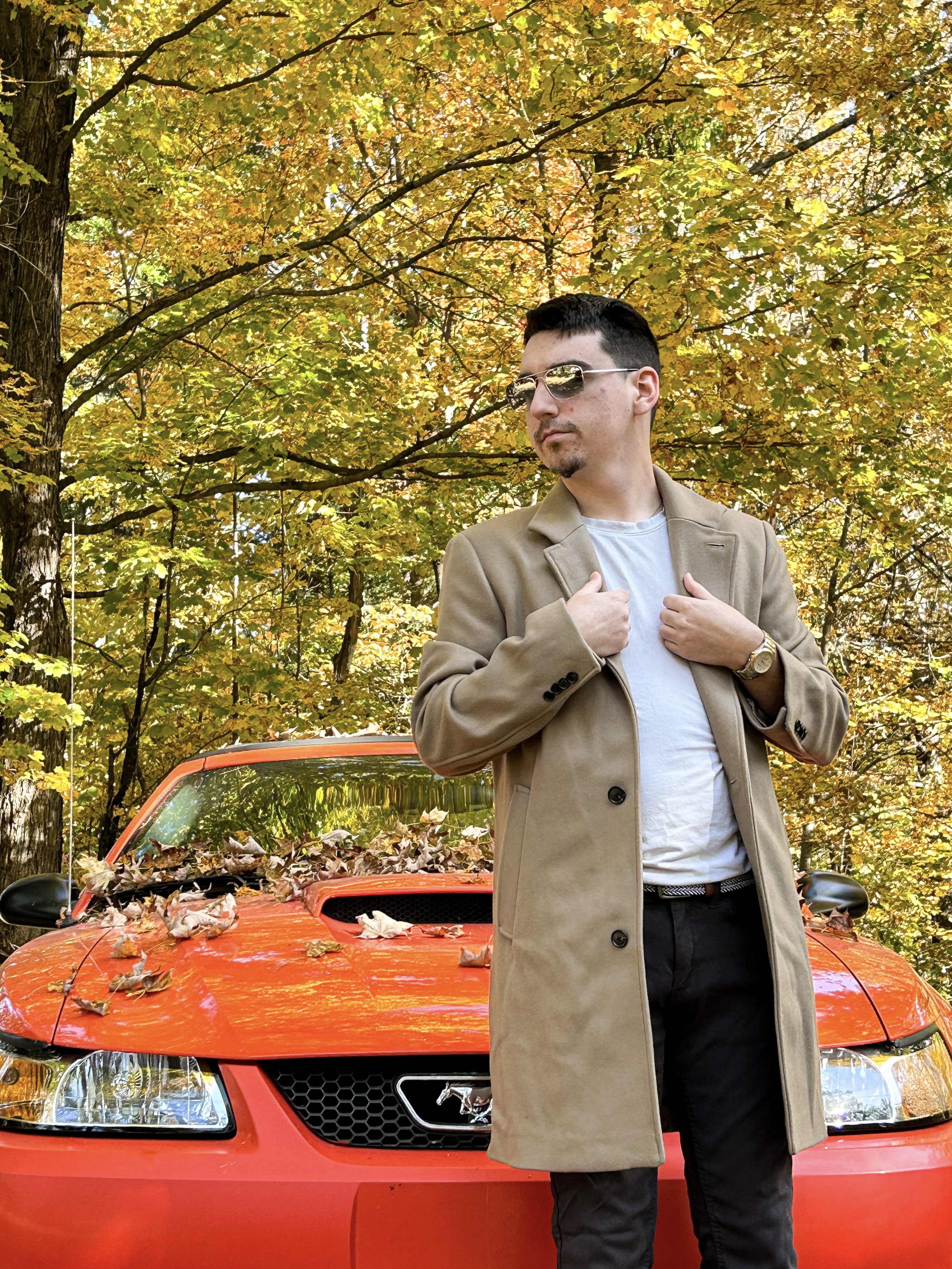 Størm standing beside a red Mustang in autumn